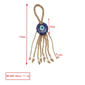 Macro view of handmade Evil Eye wall decor with blue mandala bead and jute tassels
