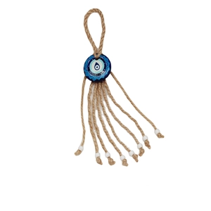 Close-up of Evil Eye wall decor with blue lotus pendant, hemp rope and white beads