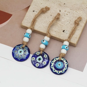 Three traditional Evil Eye Nazar amulets with hemp rope and blue floral patterned pendants