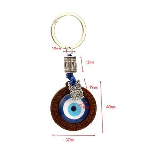 Blue Evil Eye keychain with silver owl pendant and vintage beads on white background