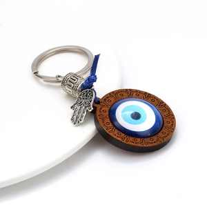 Detail of blue evil eye bead and Hamsa hand charm on a vintage style keychain