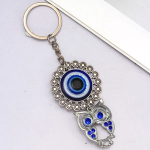 Detail of owl evil eye keychain featuring blue rhinestones and silver alloy metal link