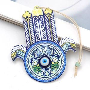 Hamsa Hand Evil Eye keychain with Tree of Life print and blue fish patterns on wood
