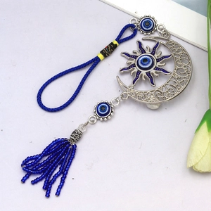 Détail d'une suspension bohème soleil et lune avec amulettes œil et franges bleues