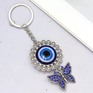 Detailed close-up of evil eye sunflower pendant and crystal butterfly keychain charm