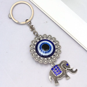 Detailed close-up of a silver elephant keychain with blue rhinestones and evil eye charm