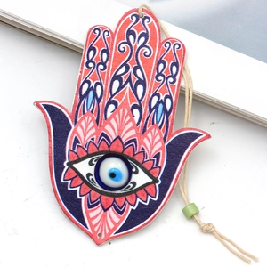 Hamsa hand keychain with colorful patterns and evil eye bead on a white background