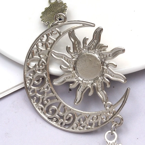 Détail macro du pendentif soleil et lune argenté avec des motifs bohèmes évidés complexes