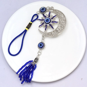 Pendentif œil porte-bonheur avec motifs soleil lune et pompons en perles bleu foncé