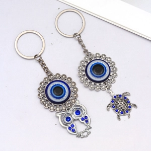 Detail of silver owl and turtle keychains with blue Evil Eye nazar and crystals