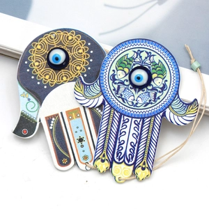 Detail showing two wooden Hamsa Hand pendants with Evil Eye and Mandala patterns