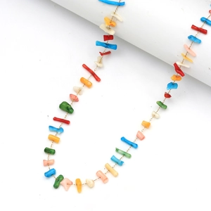 Détail d'un collier fait main avec des perles de pierres naturelles sur un fil doré