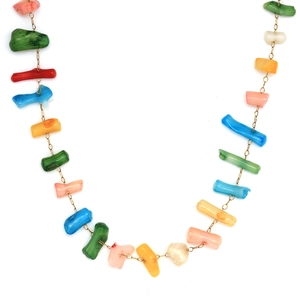 Détail d'un collier bohème doré avec des perles organiques aux couleurs vibrantes