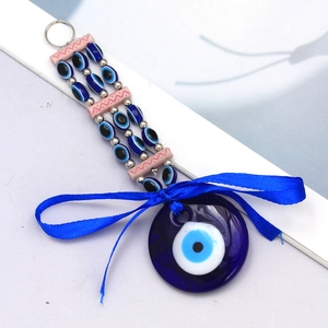 Detail of Turkish Evil Eye glass pendant with a blue silk bow and beaded keyring ornament