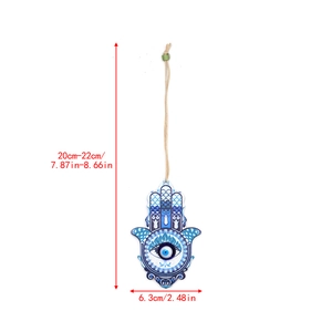 Detailed view of Hamsa Hand wall decor with blue Evil Eye and measurement markings