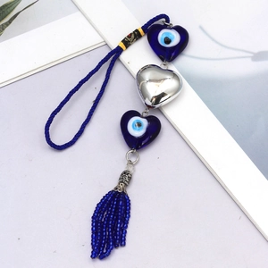 Detail of blue Evil Eye heart charms on woven rope with silver metallic bead and tassels