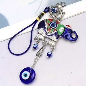 Detailed view of Turkish Evil Eye elephant pendant with blue glass beads and woven rope