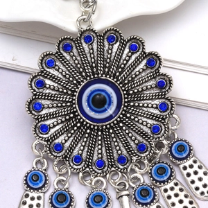 Turkish evil eye sun flower keychain with blue rhinestones and charms on white background