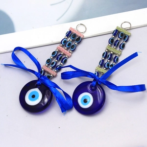 Detail of Turkish Evil Eye keychain charms with blue ribbon bows and glass beads