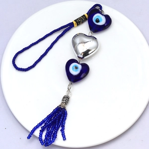 Detail of blue heart evil eye nazar amulets with silver heart and beaded tassel