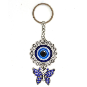 Detail of evil eye keychain with blue rhinestone butterfly pendant on silver alloy