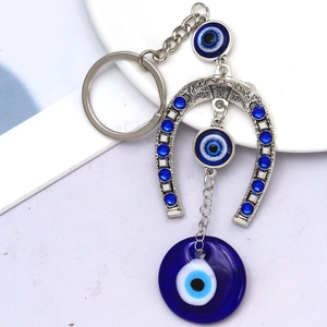 Gros plan d'un porte-clés fer à cheval serti de strass bleus avec des pendentifs œil