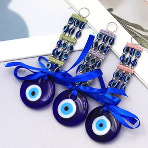 Detailed view of three Turkish Evil Eye keychains with silk bows and colorful beads