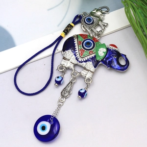 Detail of blue evil eye elephant pendant with enamel patterns and glass bead charms