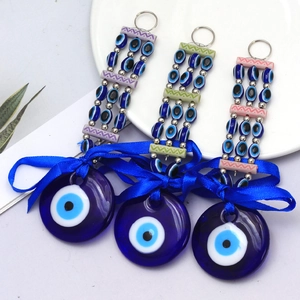 Detailed set of three Evil Eye glass charms with blue ribbons and beaded metal rings
