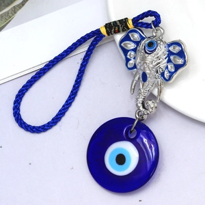 Detail of silver elephant charm with evil eye glass pendant on blue braided cord