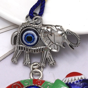 Detailed macro view of silver elephant pendant with blue evil eye and colorful enamel