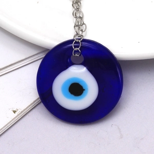 Close-up of glass evil eye pendant with deep blue and white concentric circles