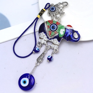 Close-up of blue evil eye elephant pendant with colorful patterns and woven rope