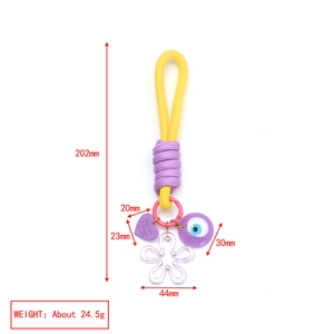Dettaglio con occhio blu, cuore viola e ciondoli floreali con misure dimensionali