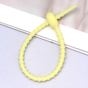 Macro shot of flexible yellow silicone cable tie with adjustable multi-hole locking strap