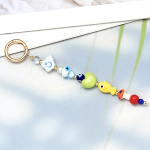 Detail of colorful beaded keychain with Turkish evil eye and cute smiley face charms