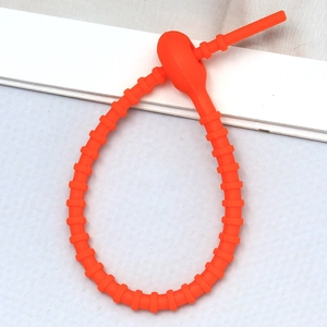 Detailed view of orange silicone cable tie with non-slip texture and locking buckle mechanism