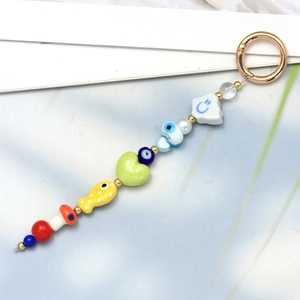 Macro shot of colorful beaded keychain with Turkish blue evil eye and gold spring clasp