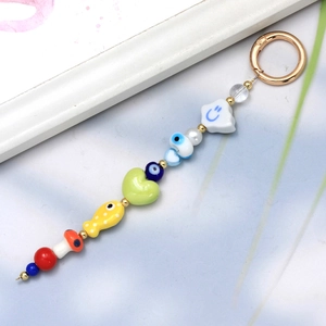 Detailed view of beaded keychain with colorful mushroom and evil eye charms