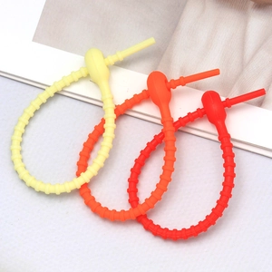 Three flexible silicone cable ties in yellow and red with self-locking gear texture