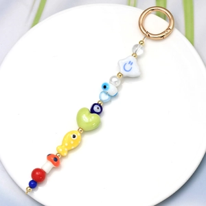 Detail view of colorful beaded keychain with blue evil eye, stars, and mushroom charms