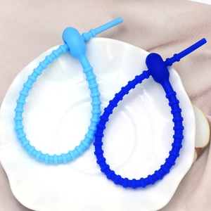 Detailed view of adjustable blue silicone cable ties organized on a white ceramic plate