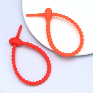 Detail of adjustable silicone cable ties in red and orange with non-slip texture