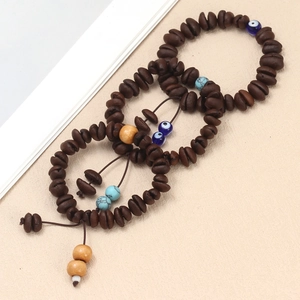 Close-up of coffee bean beads and blue evil eye charms on ethnic style handmade bracelets