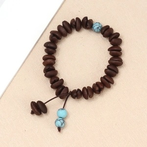 Detailed macro view of coffee bean beaded bracelet with turquoise evil eye charms and cord