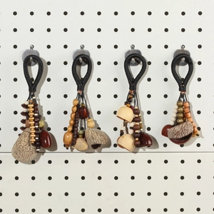 Detail view of handmade ethnic charms with woven rope, wooden beads and natural nut shells