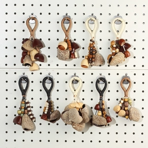 Detailed collection of nine handmade seed pod charms with woven ropes and wooden beads