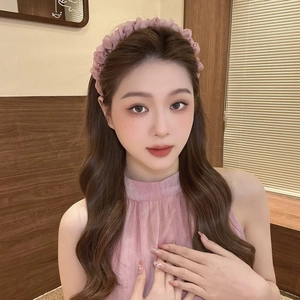 Détail d'un serre-tête rose clair en seersucker avec texture plissée sur un mannequin