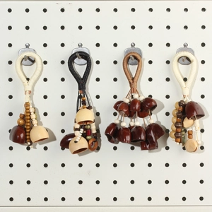Detail showing four handmade ethnic nut shell charms with woven ropes and wooden beads