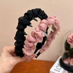 Détail de la texture gaufrée plissée des bandeaux larges en noir et rose élégant